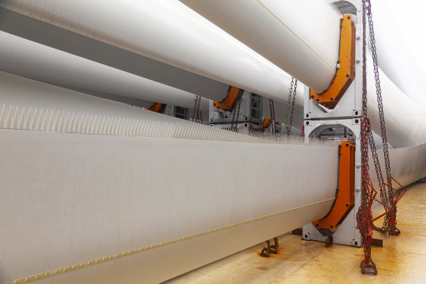 风力涡轮机的叶片用特殊的紧固件固定在船的甲板上，以便在船上进行海上运输。图片下载