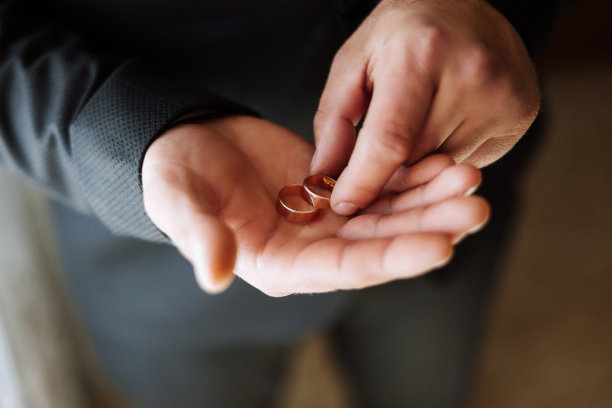 顽皮兴奋的年轻新郎扔结婚戒指。手扔结婚戒指的特写照片。高质量照片图片下载