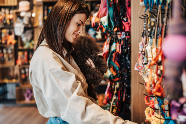 宠物店里有个带着贵宾犬的年轻女人图片下载