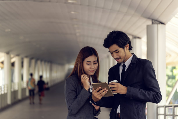 年轻的亚洲商人微笑着在上班前喝杯咖啡放松一下。情侣们在现代都市里一起喝咖啡。商务人士在办公室端着一杯咖啡图片下载