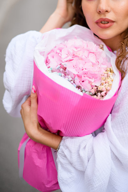 非常漂亮的女孩穿着白色的衣服，拿着一束粉红色的花图片下载