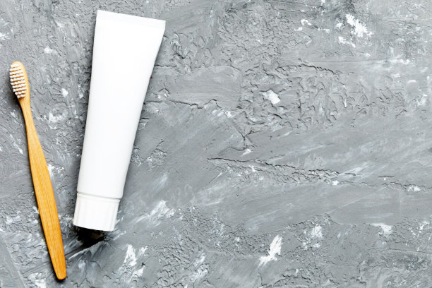 牙膏和牙刷的顶部视图与彩色背景上的复制空间。平的。口腔卫生。浅色背景的口腔护理产品。身体护理理念图片下载