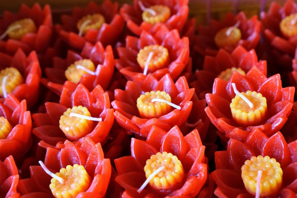 一盘红色蜡烛和黄色花朵的照片。图片下载