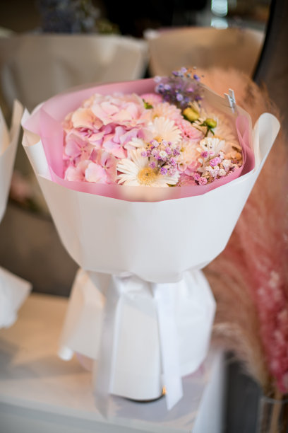 背景模糊的桌子上放着一束装在酒瓶里的鲜花图片下载