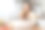 在现代厨房里吃早餐时吃羊角面包的快乐女人的照片。图片下载