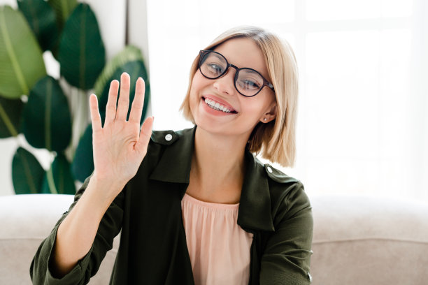 年轻的自由职业者的特写照片，穿着正装，戴着眼镜，在视频通话中看着相机图片下载