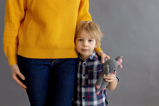 悲伤的小孩，金发男孩，在家拥抱他的母亲图片下载