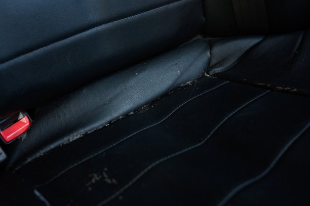 损坏，磨损，灰尘，裂纹的真皮汽车座椅。修补概念，缝制新汽车坐垫。图片下载