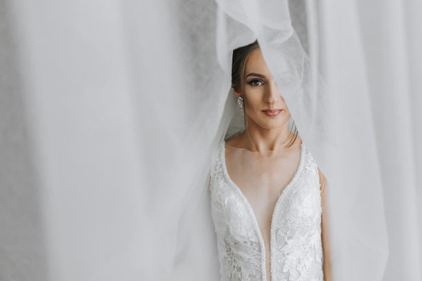 一个黑发女孩正在为婚礼做准备。新娘穿着婚纱，发型优雅，妆容奢华的肖像照，新娘戴着面纱的照片图片下载