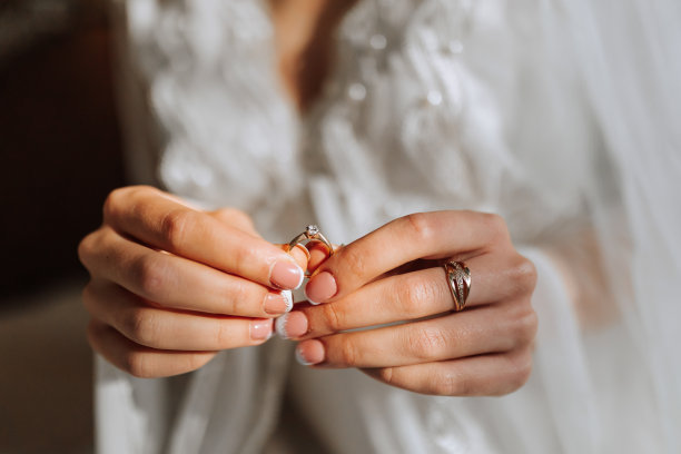 一个身穿白袍的女孩手里拿着一枚镶着宝石的女子金戒指，特写照片图片下载