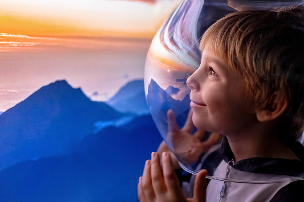 可爱的孩子，男孩，梦想成为宇航员，飞向太空。月亮的反射图片下载