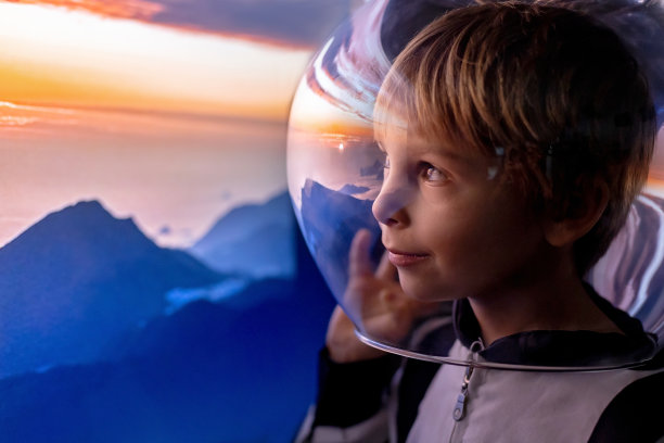可爱的孩子，男孩，梦想成为宇航员，飞向太空。月亮的反射图片下载