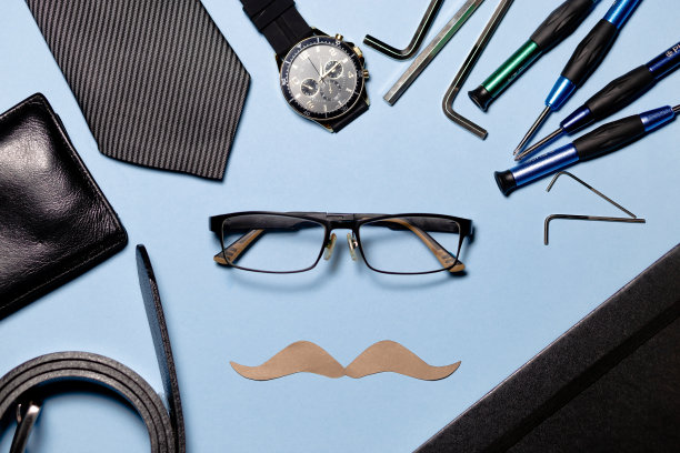 几件工具，一条领带和一张纸胡子，背景是浅蓝色的。图像传达了一种有趣和幽默的氛围。父亲节概念。copyspace图片下载