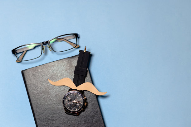 几件工具，一条领带和一张纸胡子，背景是浅蓝色的。图像传达了一种有趣和幽默的氛围。父亲节概念。copyspace图片下载