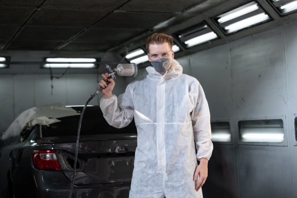 汽车服务人员在防护罩涂装车身。Oxus图片下载