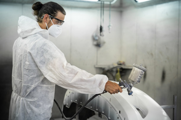 汽车服务人员在防护罩涂装车身。Oxus图片下载