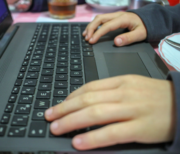 男孩在午饭后用笔记本电脑图片下载