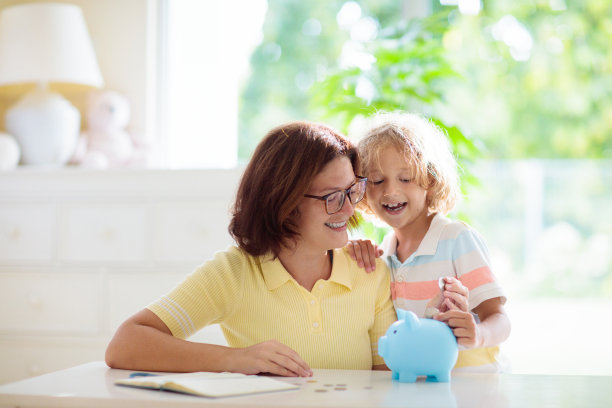 孩子把硬币放进存钱罐。孩子和钱。图片下载