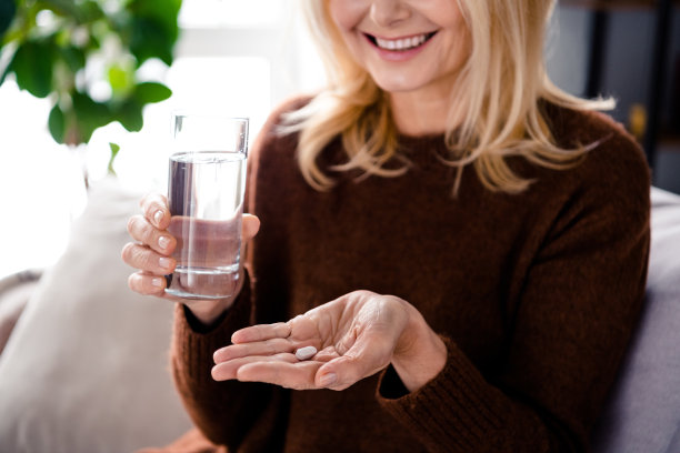 裁剪照片开朗积极退休女士手臂手掌持有胶囊服用维生素保健在家度假病假在室内图片下载