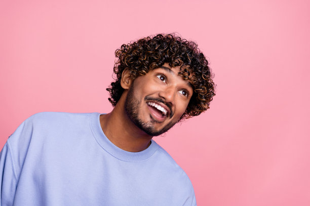 照片开朗的高兴感兴趣的家伙穿蓝色的衣服看广告牌新闻海报空白的空间孤立在粉红色的背景图片下载