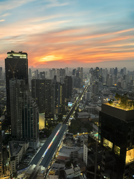 泰国曼谷市中心城市景观摩天楼天际线的特写图片，戏剧性，大气，蓝色和橙色的日落，多云的天空图片下载