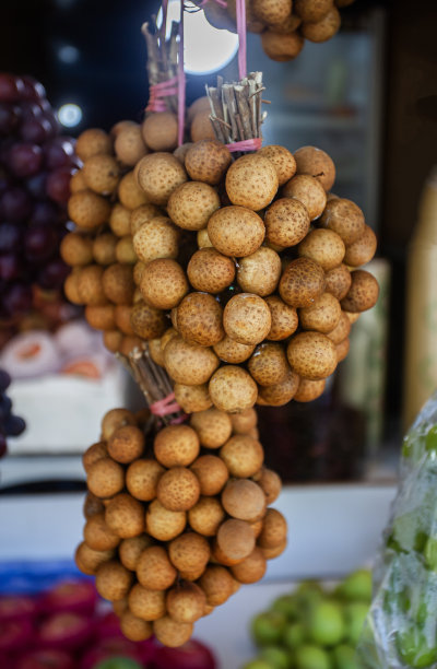 在水果店里，把桂圆捆起来陈列。香甜爽口的热带水果。图片下载