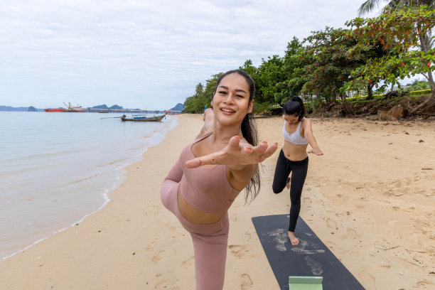 两名亚洲女性在海滩上练习瑜伽的正面照片图片下载