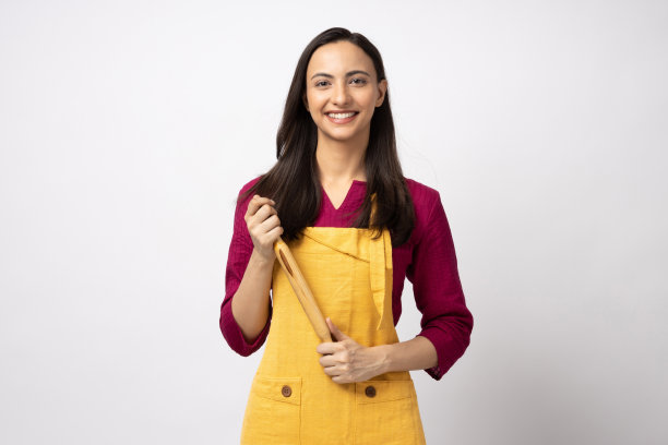 年轻女厨师的肖像穿着黄色围裙孤立白色背景股票照片图片下载