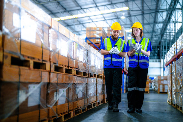 工人使用激光条码扫描器检查库存货物的运输。男性和女性检查商店工厂。工业工厂仓库。从事仓库管理的物流员工。图片下载