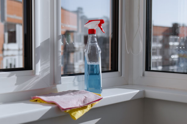 清洁窗户配件。Сleanser喷雾器和粉色、黄色抹布、超细纤维布放在窗台和窗外的城市街道上图片下载