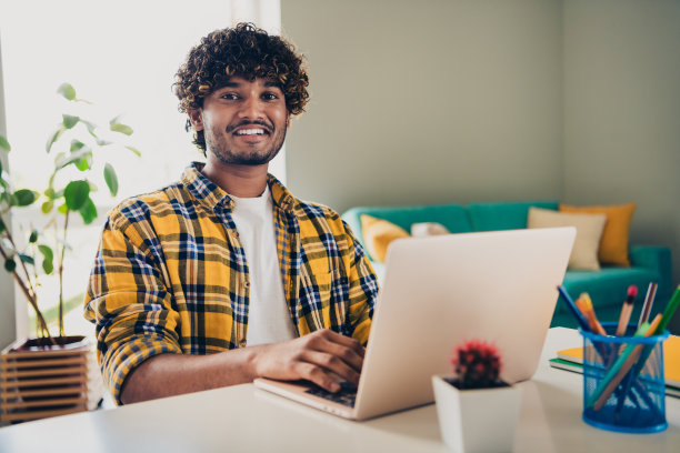 照片开朗的好男人穿着衬衫坐在桌子工作空间在大学学习从家里舒适的公寓室内图片下载
