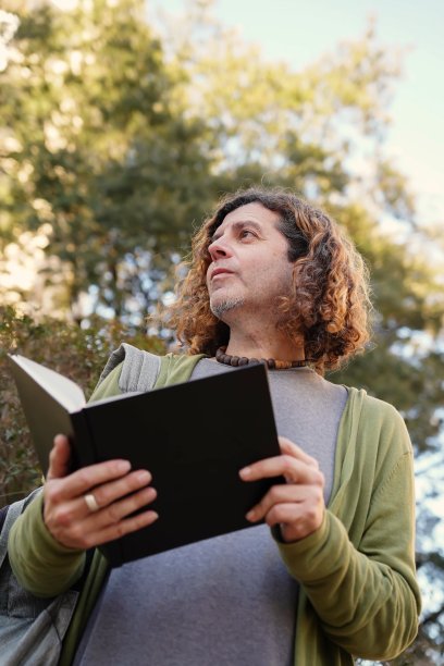 帅气成熟的大学教授在户外看书。世界读书日图片下载