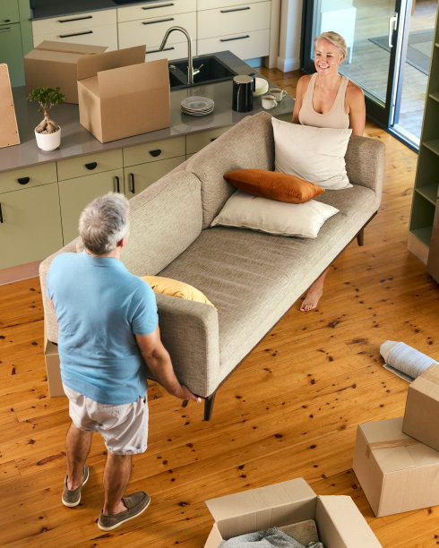 搬家那天，一对成熟夫妇扛着沙发、搬着家具搬进新家的俯拍照片图片下载