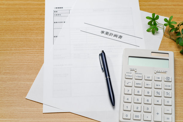 商业计划书、笔和计算器放在木桌上图片下载