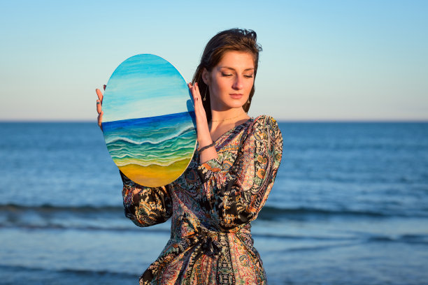 穿着礼服的女人拿着画图片下载