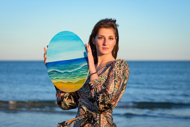 穿着礼服的女人拿着画图片下载