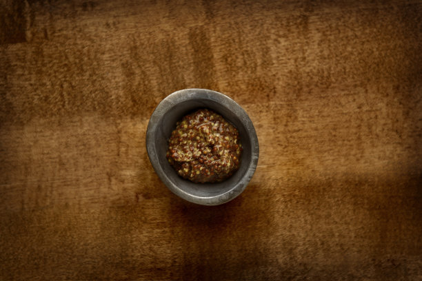 木桌上一碗有质感的芥末的俯拍照片图片下载