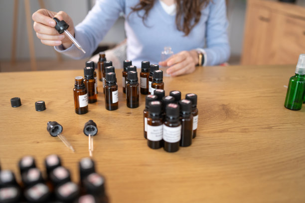 女人坐在桌子旁，周围都是精油图片下载