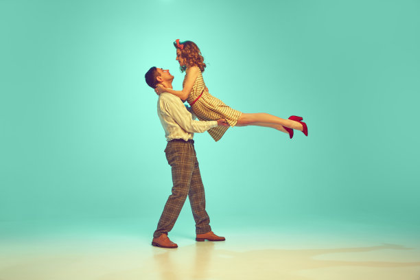 动态肖像年轻迷人的夫妇跳舞在复古风格的衣服对梯度薄荷背景。图片下载