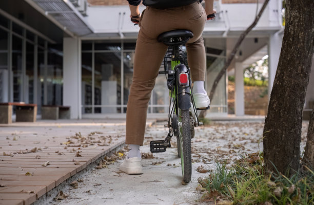 年轻的亚洲商人骑自行车上班，减少空气污染，保持健康。图片下载