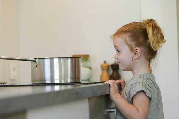 小女孩在厨房里拿着平底锅图片下载