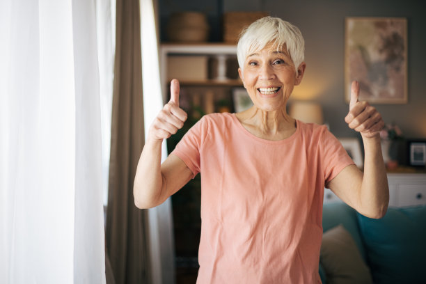 一个美丽成熟的女人在客厅竖起大拇指的照片图片下载