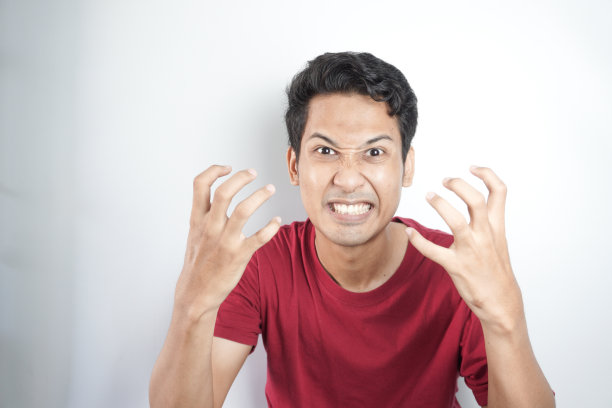 英俊的男子在白色背景上以愤怒的手势生气图片下载