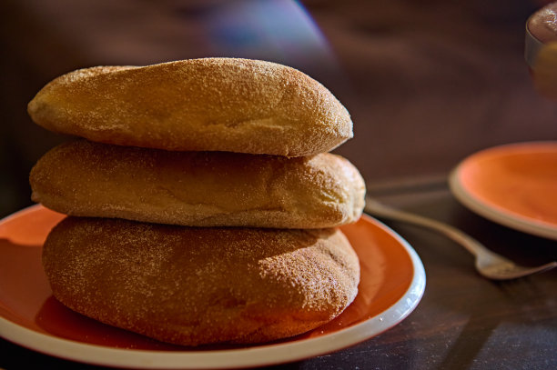 一堆刚烤好的全麦面包放在陶瓷盘子里。为广告和美食博客拍摄特写食物照片图片下载