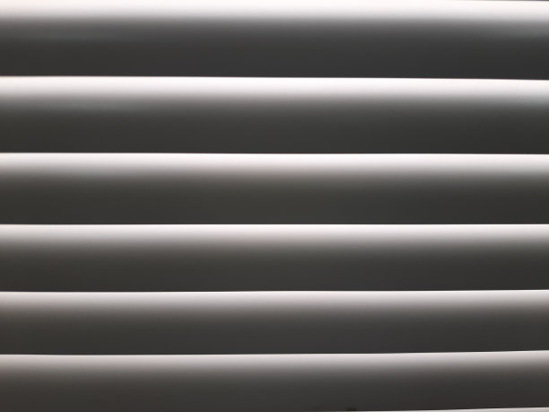 光线穿过黄色金属窗帘和黄色墙壁的缝隙图片下载