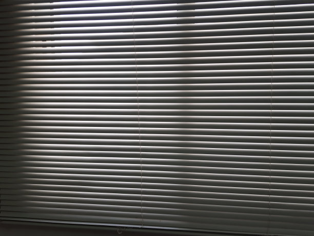 光线穿过黄色金属窗帘和黄色墙壁的缝隙图片下载