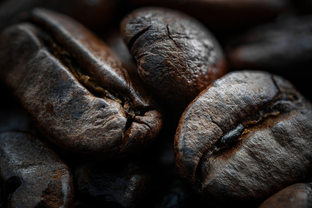 近距离微距照片的整个烘焙咖啡豆丰富和黑暗。纹理和纹理。木质桌面。背景图片下载