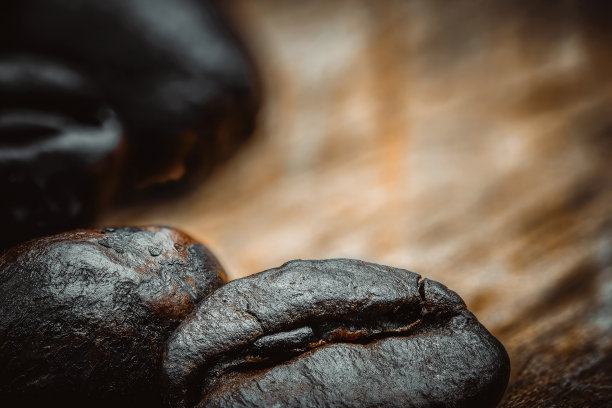 近距离微距照片的整个烘焙咖啡豆丰富和黑暗。纹理和纹理。木质桌面。背景图片下载