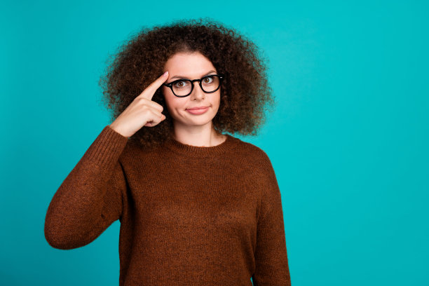 聪明的商业女性用手指着额头的照片显示，在蓝色背景下，在办公室开会时进行头脑风暴图片下载