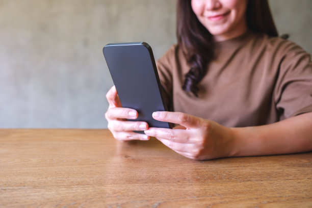 一名年轻女子手持并使用智能手机的特写图片图片下载